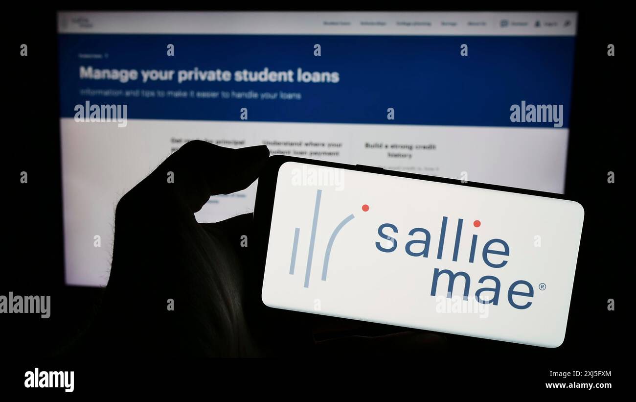 Stoccarda, Germania, 02-23-2024: Persona che detiene il cellulare con il logo della società finanziaria statunitense SLM Corporation (Sallie Mae) di fronte alla pagina web aziendale. Foto Stock