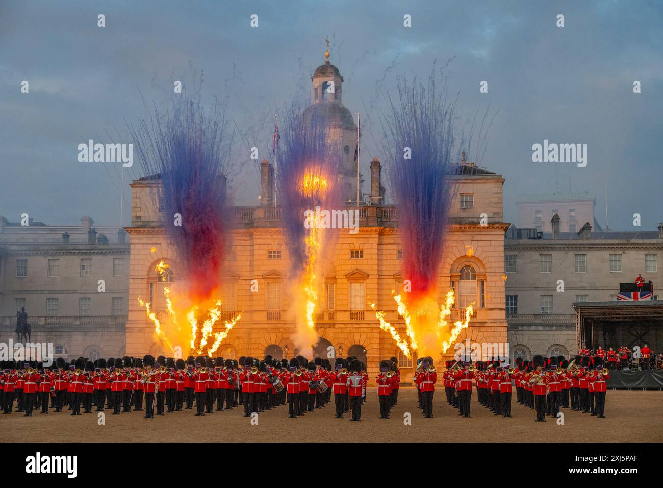 Horse Guards Parade, Londra, Regno Unito. 16 luglio 2024. Il Beating Retreat della Household Division viene eseguito di fronte a un pubblico ogni sera dal 16 al 18 luglio, un colorato concorso di musica militare e trapano di precisione effettuato dalle bande montate della Household Cavalry, dalle bande massaggiate della Household Division e dagli artisti ospiti. Immagine: Uno spettacolare spettacolo pirotecnico sullo sfondo delle guardie a cavallo termina lo spettacolo con le bande delle guardie massaggiate in primo piano. Crediti: Malcolm Park/Alamy Live News Foto Stock