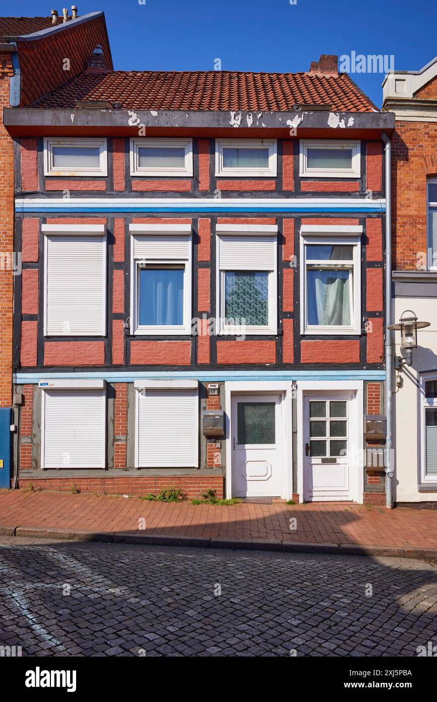 Casa dipinta di rosso e mezza in legno contro un cielo blu senza nuvole a Stade, città anseatica, distretto di Stade, bassa Sassonia, Germania Foto Stock