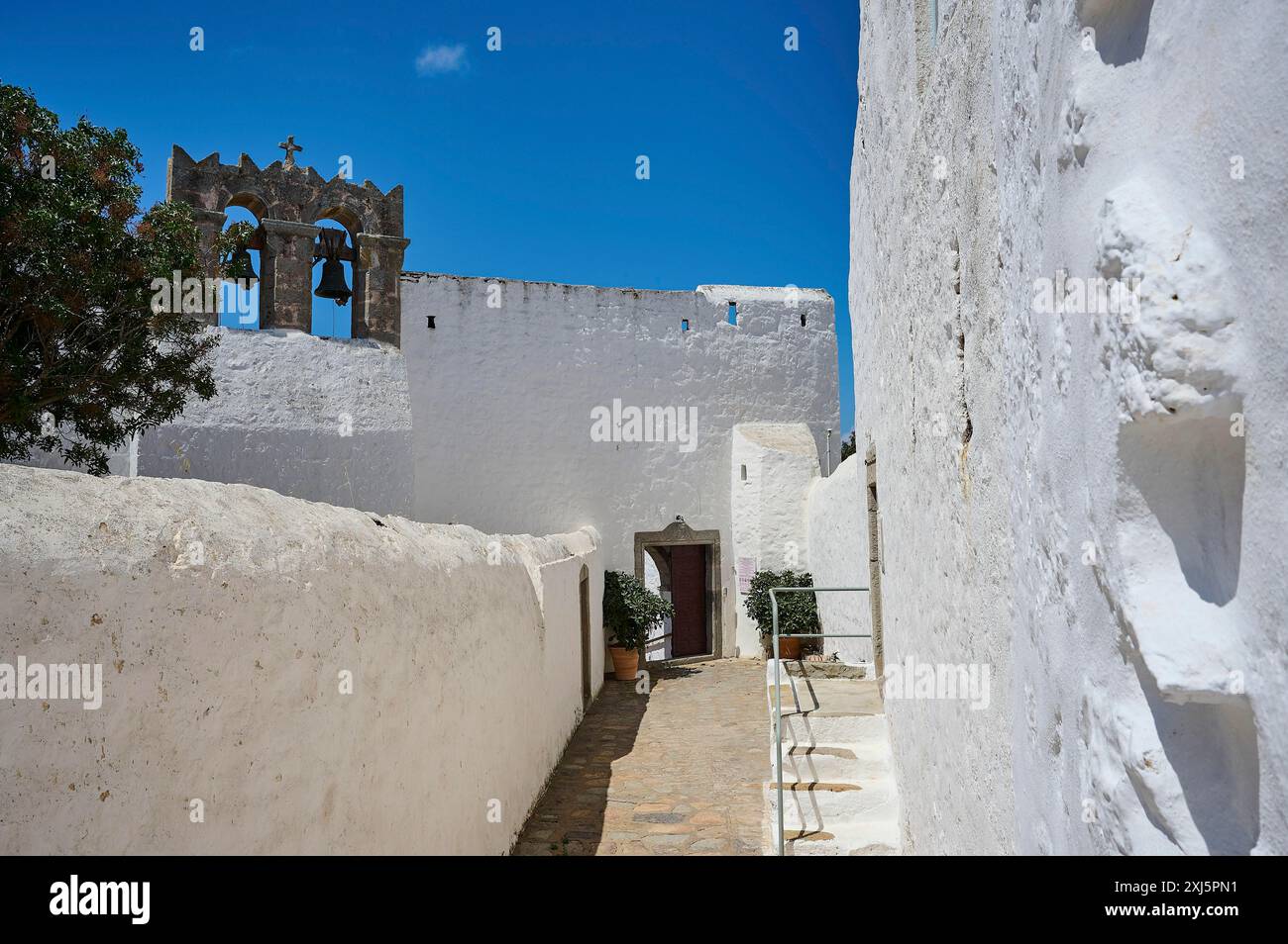 Percorso in un edificio bianco con campanile e cielo azzurro, il monastero di Zoodochou Pigis, le sorgenti della vita, Chora, Patmos, Dodecaneso, greco Foto Stock