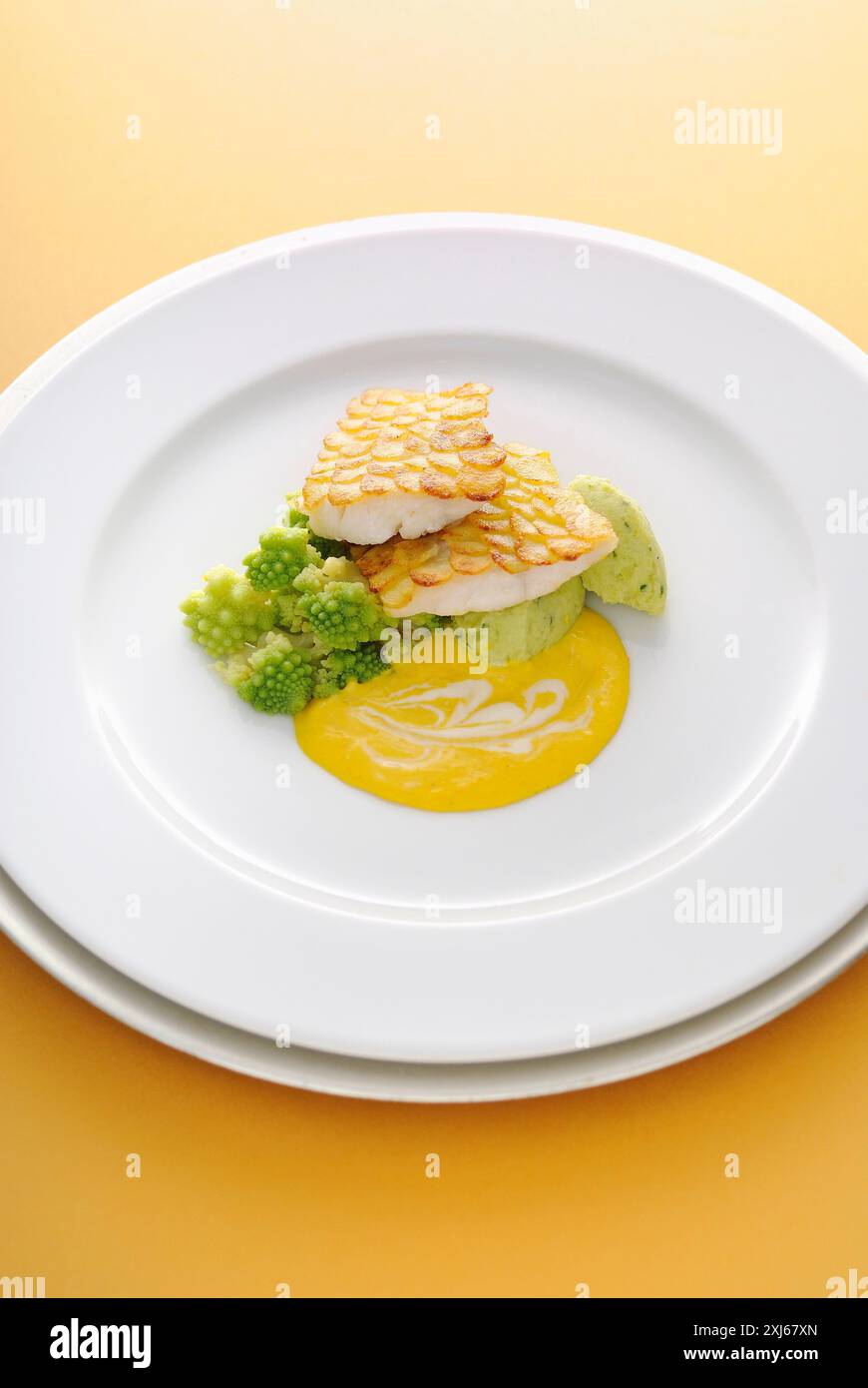 Filetti di pesce persico con scaglie di patate, salsa cremosa al limone Foto Stock