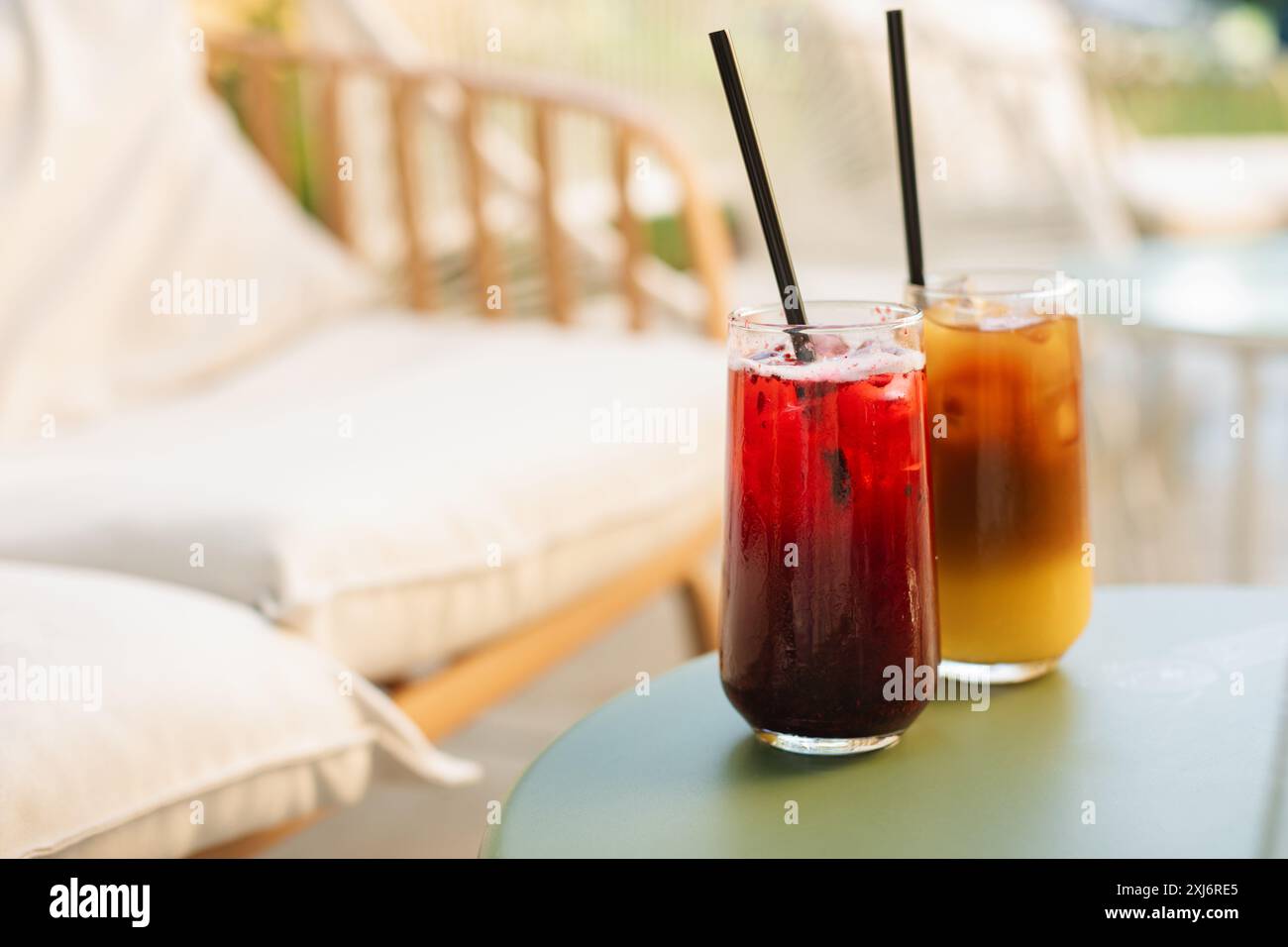 Rinfrescanti drink estivi in bicchieri alti con cannucce sul tavolo, sulla terrazza estiva. Foto Stock