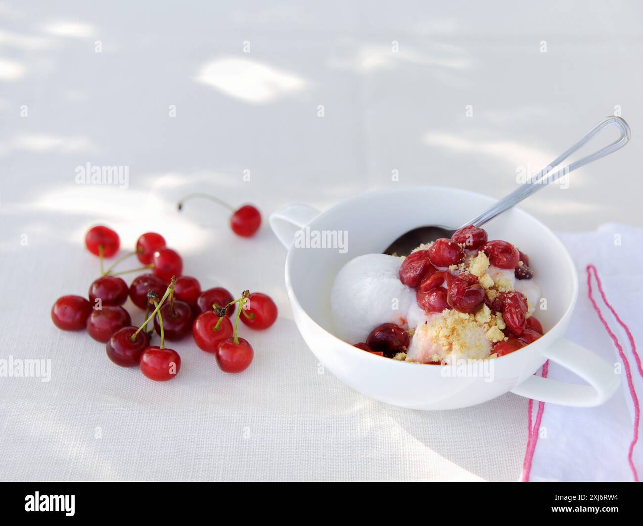 Gelato allo yogurt, ciliegie stufate e crumble alle mandorle Foto Stock