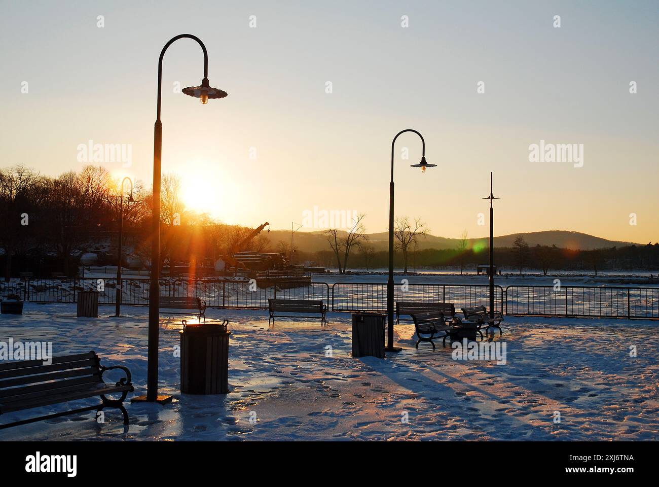 Il sole tramonta su un parco in inverno Foto Stock