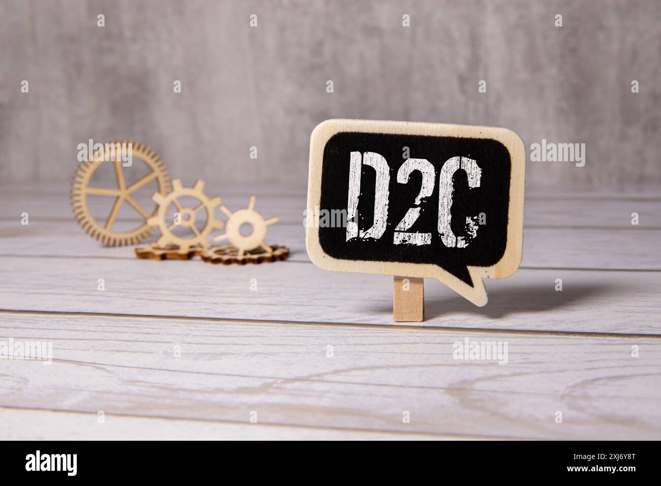 D2C - pubblicità DTC Direct-to-Consumer - acronimo su cubi di legno su colonne di numeri sullo sfondo. D2C, acronimo su cubi di legno. Background - docume Foto Stock