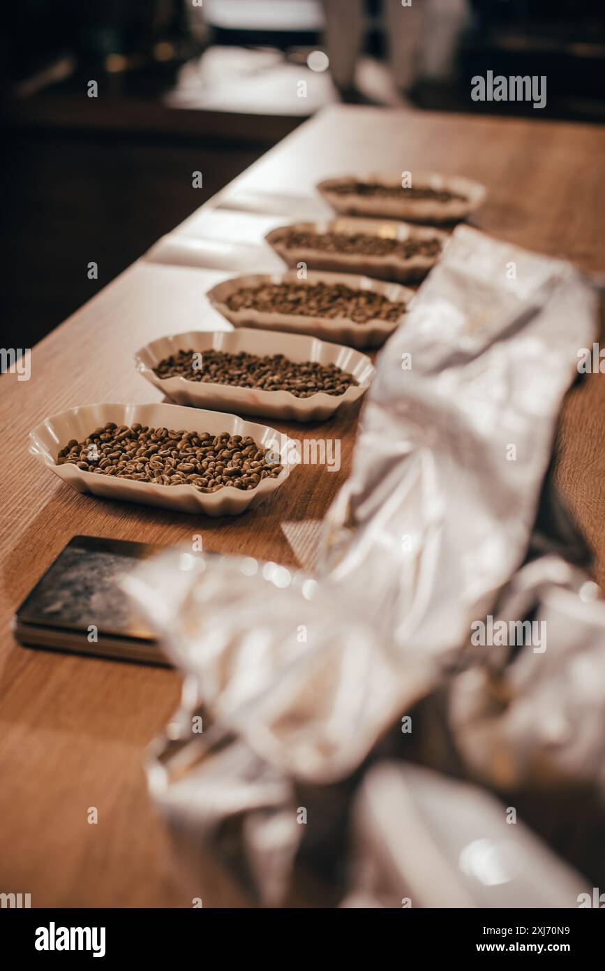 Vista ravvicinata di disposti a bocce con i chicchi di caffè per la funzione di alimentare sul piano portapaziente in legno Foto Stock