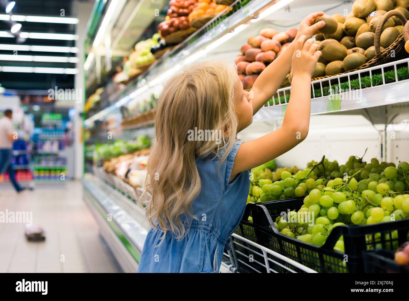 Femmina adorabile bambino scegliendo frutti nel supermercato Foto Stock