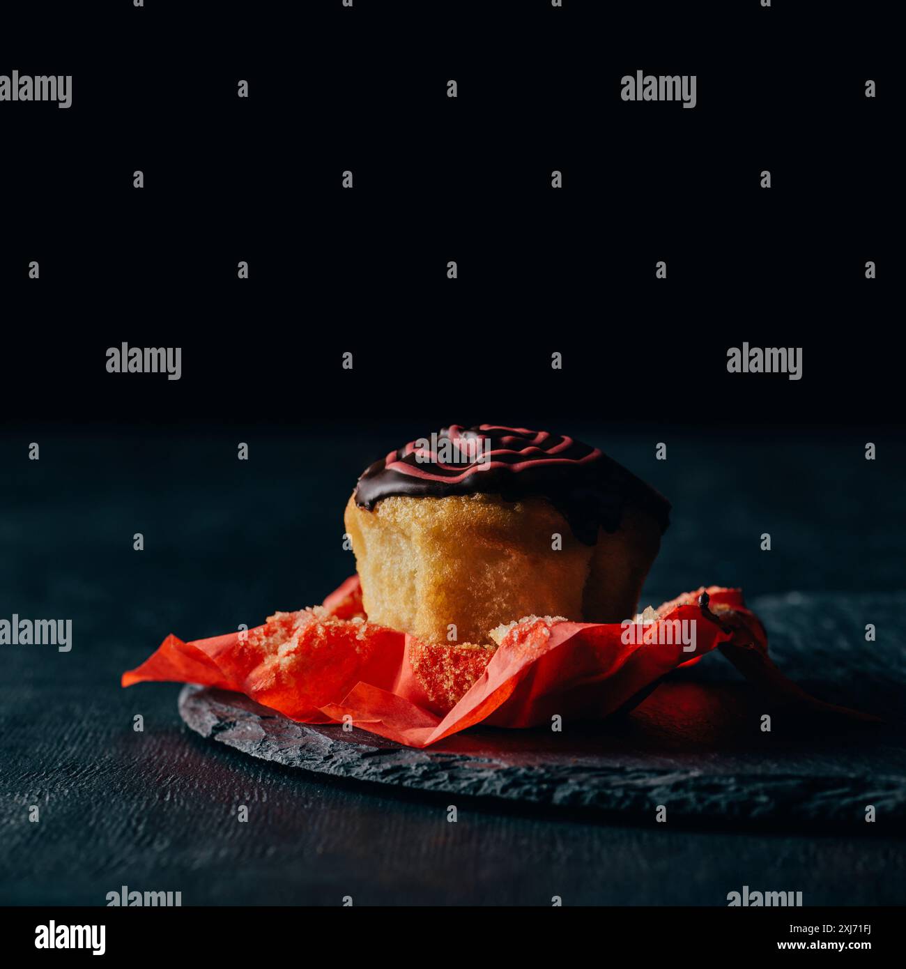 Muffin dolci con glassa di cioccolato sulla scheda di ardesia Foto Stock