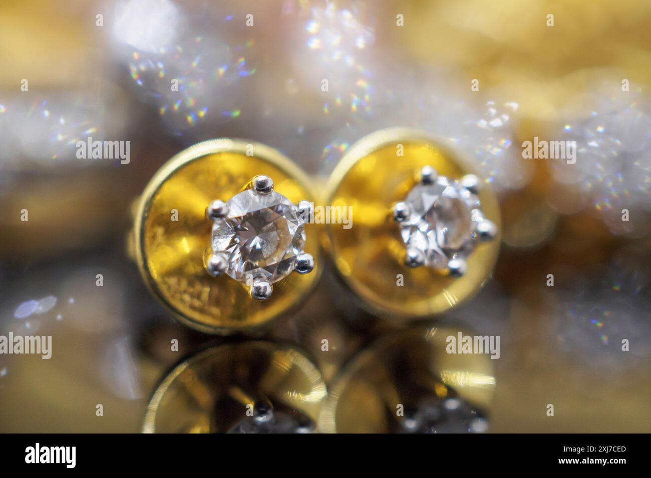 Orecchini diamantati gioielli in oro di lusso con riflesso su sfondo nero Foto Stock