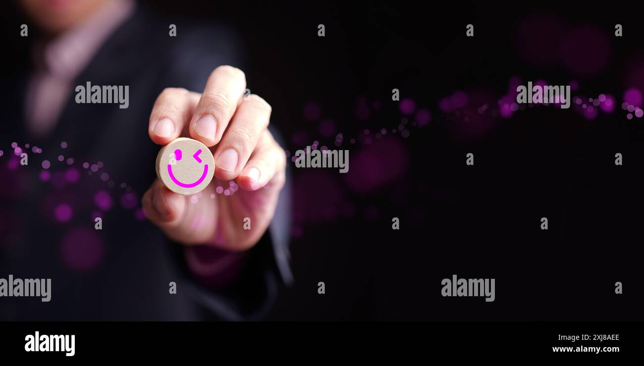Concetto di felicità e soddisfazione. Un uomo ha un volto sorridente su sfondo scuro che rappresenta essere soddisfatto e felice, positivo e benessere Foto Stock