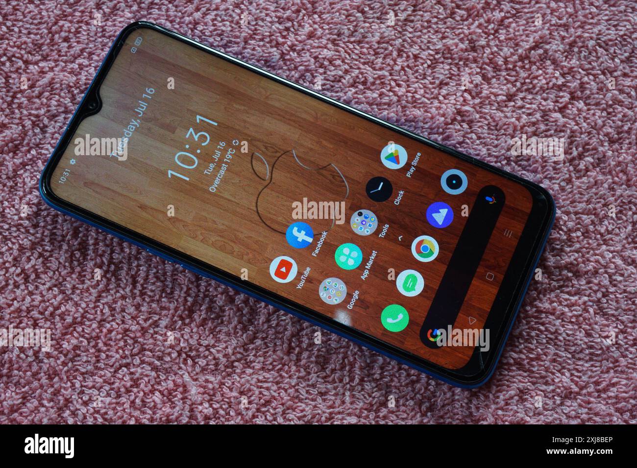 Terengganu, Malesia - 2 agosto 2024 : primo piano del telefono realme con sfondo Apple iphone su sfondo rosso Foto Stock