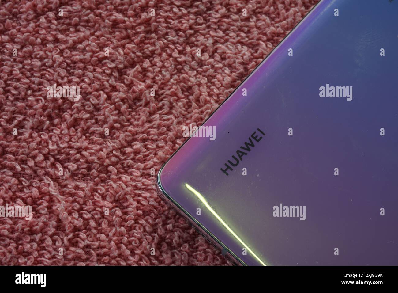 Terengganu, Malesia - 2 agosto 2024 : primo piano dello smartphone huawei sul pannello posteriore su sfondo rosso. Logo Huawei sul telefono. Logo Huawei. Foto Stock