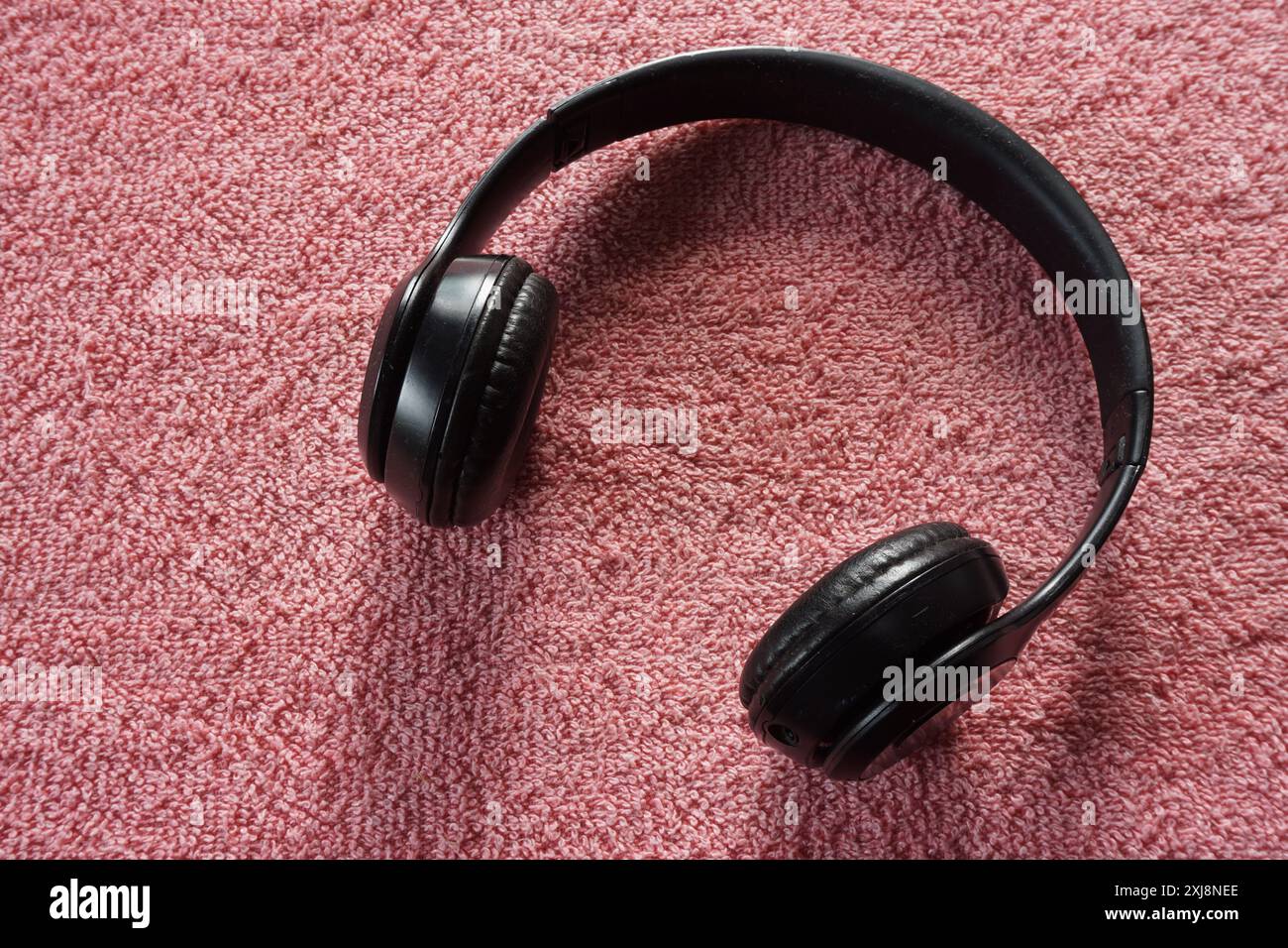 Primo piano delle cuffie wireless bluetooth nere su sfondo rosso Foto Stock