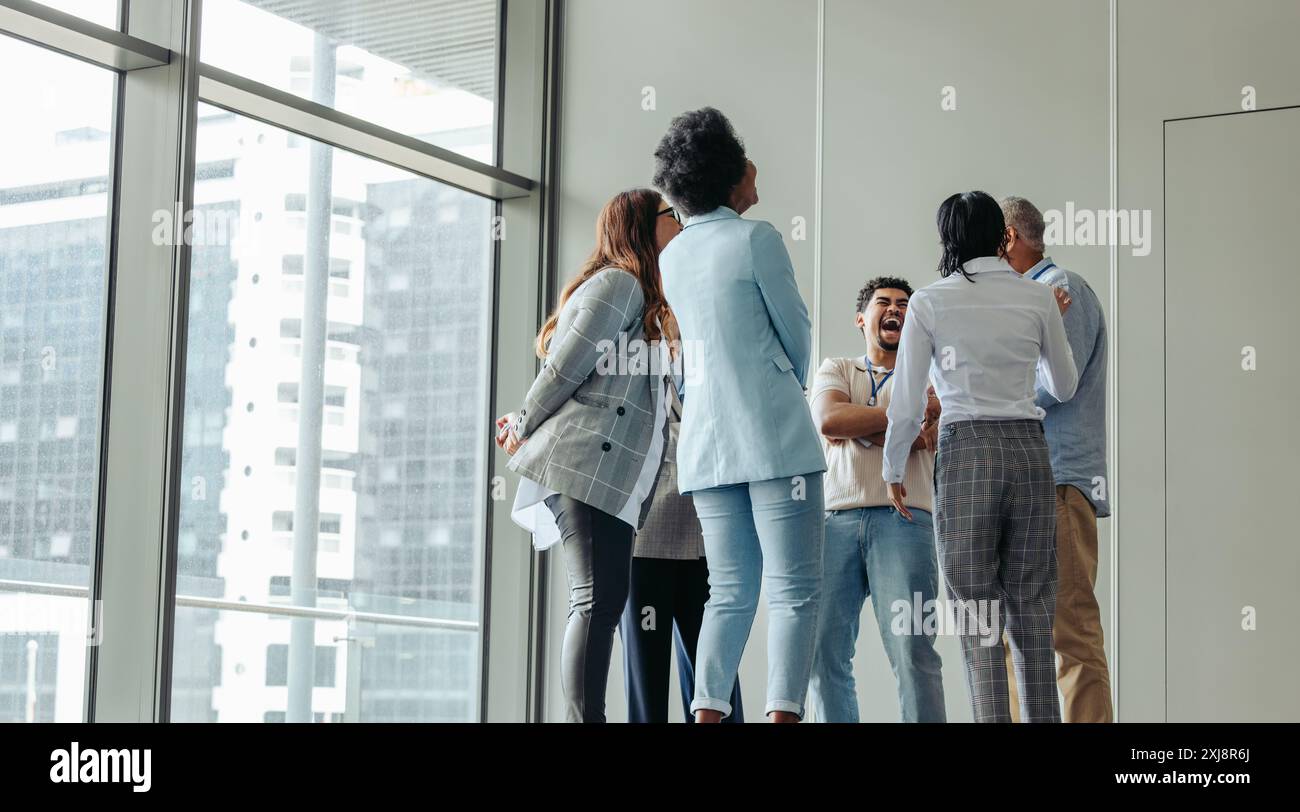 Gruppo diversificato di professionisti che collaborano a un evento di conferenza aziendale, si impegnano in una conversazione vivace e creano connessioni. Foto Stock