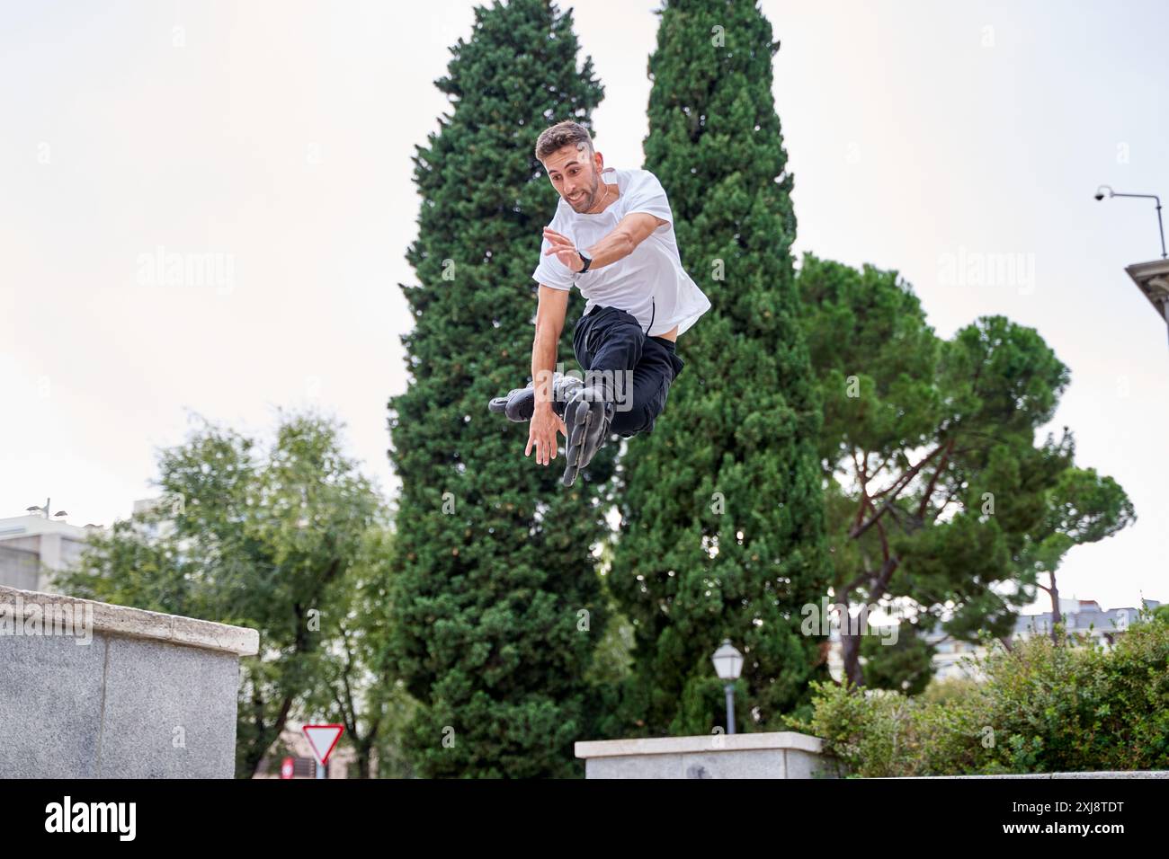 Pattinatore su pattini estremi che esegue acrobatici saltando al cielo nuvoloso - concetto di stile di vita alternativo Foto Stock