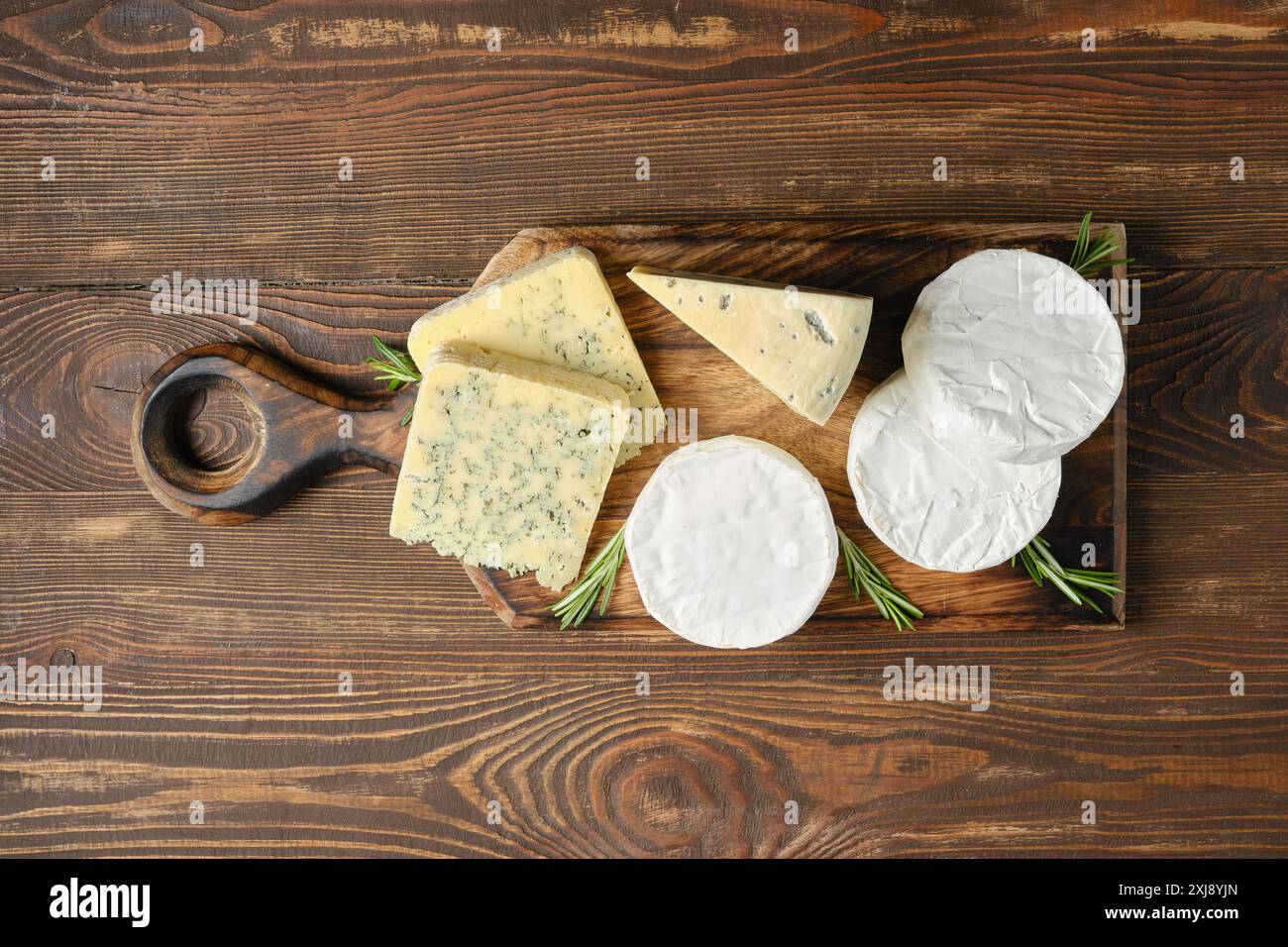 Vista dall'alto del piatto di legno con assortimento di formaggi Foto Stock