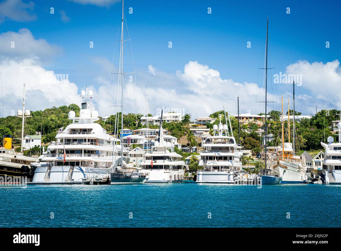 Diversi mega yacht e superyacht bellissimi e immacolati al molo di English Harbour, una famosa isola caraibica di Antigua conosciuta per la stagione degli yacht e le regate Foto Stock