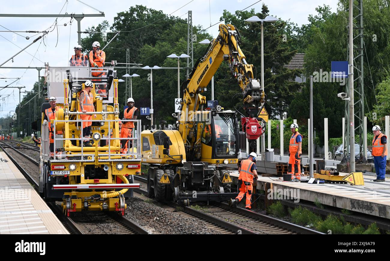 17 luglio 2024, Assia, Mörfelden-Walldorf: I lavoratori sono alla stazione di Walldorf con macchinari pesanti per l'edilizia. La chiusura completa di cinque mesi della linea ferroviaria tra Francoforte e Mannheim iniziò la notte del 16 luglio 2024. La cosiddetta Riedbahn è la prima delle 41 linee che devono essere completamente modernizzate entro il 2031. Foto: Arne Dedert/dpa Foto Stock