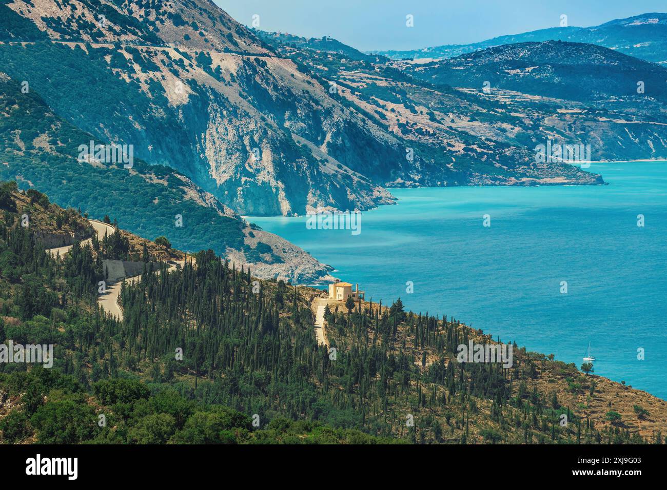 Paesaggio rurale con casa in collina circondata da vegetazione verde, con vista sul mare turchese, Cefalonia, Isole Ionie, Isole greche, Grecia, Europ Foto Stock