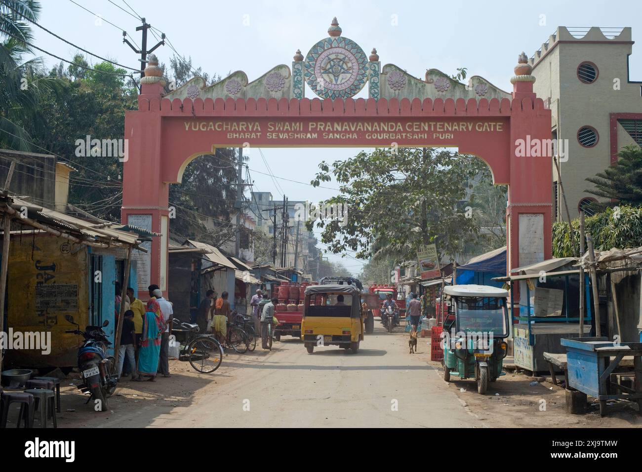 Un'arcata commemorativa per il quartiere del mercato dietro le quinte con gli acquirenti e il traffico locale, Puri, il più antico dei quattro sacri centri religiosi indù dell'India Foto Stock