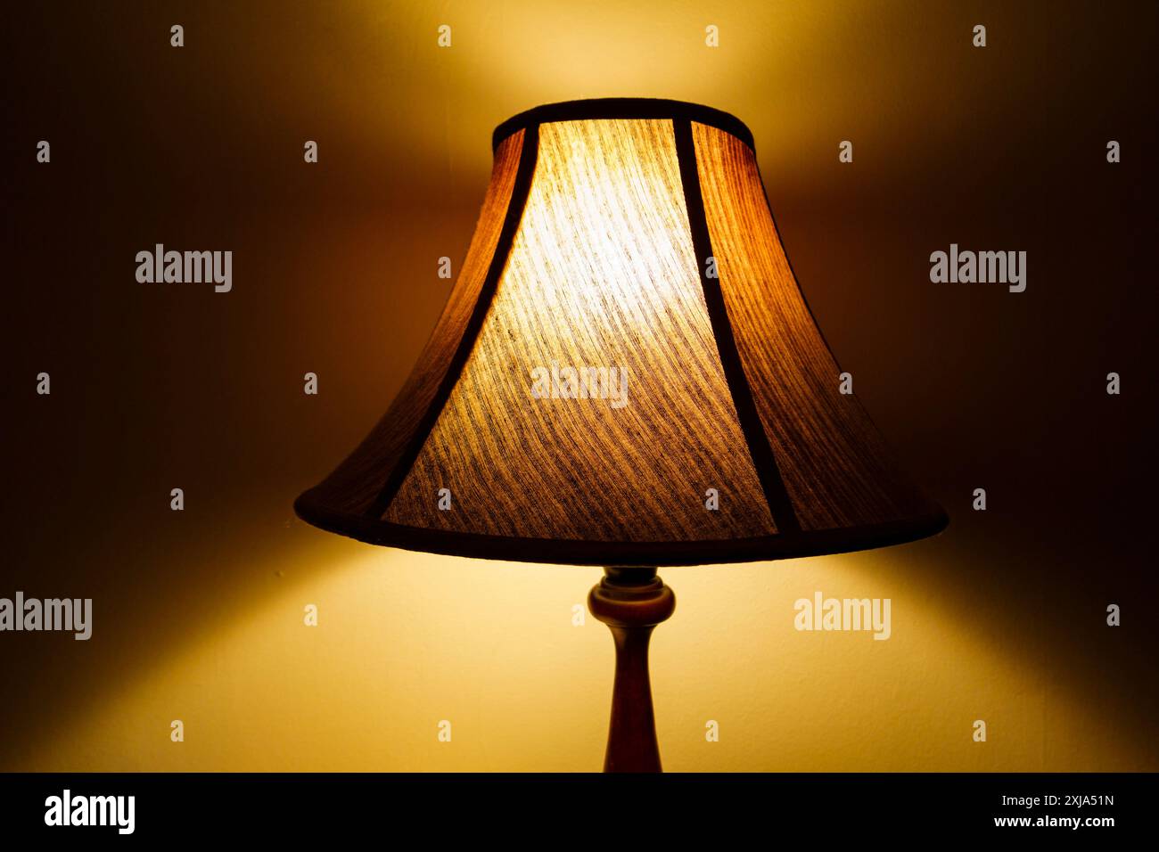 Stanza illuminata da una lampada illuminata di notte, ombre sulla parete. amp Foto Stock