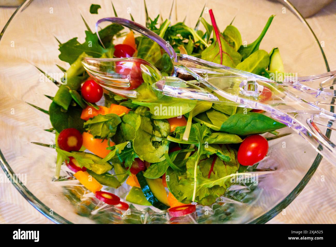 Vista dall'alto dell'insalata in un recipiente di vetro trasparente, foglie di insalata fresche e pomodori. Foto Stock
