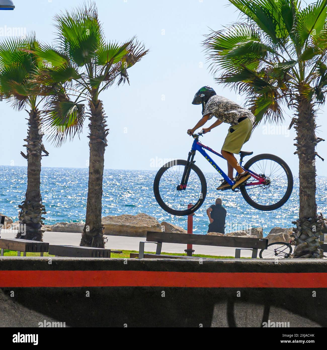 Un ragazzo che esegue una acrobazia con una bicicletta in uno skate Park a Tel Aviv, Israele Foto Stock