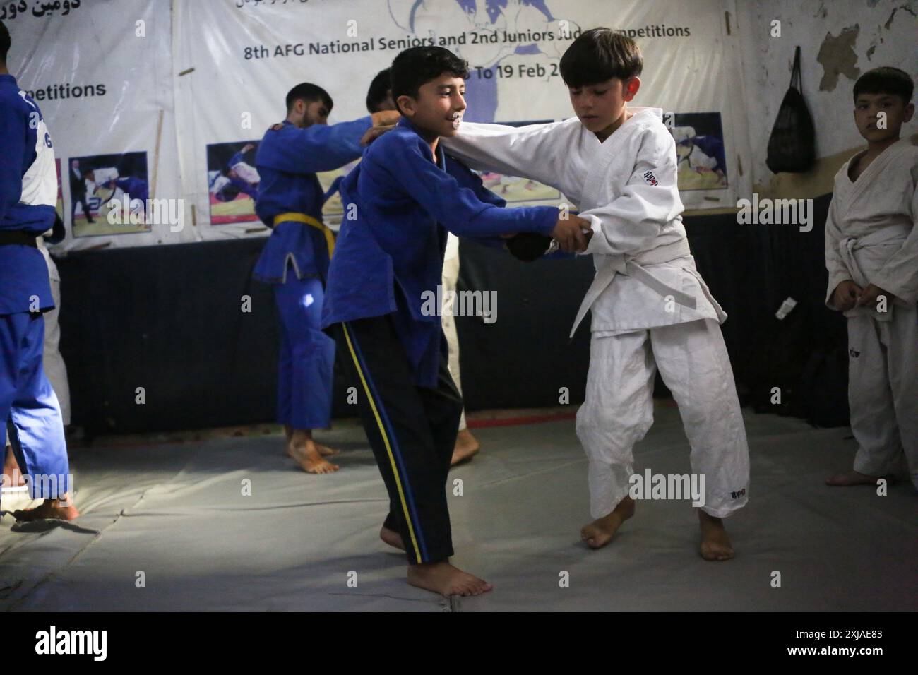 Kabul, Afghanistan. 17 luglio 2024. I bambini praticano judo in un club di judo a Kabul, la capitale dell'Afghanistan, il 17 luglio 2024. In vista delle Olimpiadi di Parigi del 2024, Mohammad Samim Faizad, l'olimpico afgano, è ora impegnato ad allenarsi in un club di judo a Kabul. Allenato da suo zio, ex olimpico che ha partecipato alle Olimpiadi di Londra 2012, il ventiduenne Faizad si dedica anche a fare da mentore ai giovani atleti. Spera di coltivare i futuri olimpici. Nonostante un ambiente di allenamento duro, Faizad non ha perso tempo a fare i preparativi completi. Crediti: Saifurahman Safi/Xinhua/Alamy Live News Foto Stock