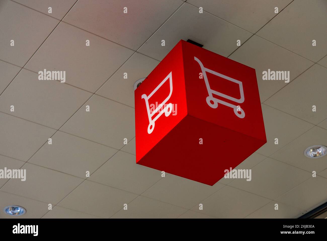 Aggiungi al carrello banner pubblicitario rosso con carrello in ipermercato Foto Stock