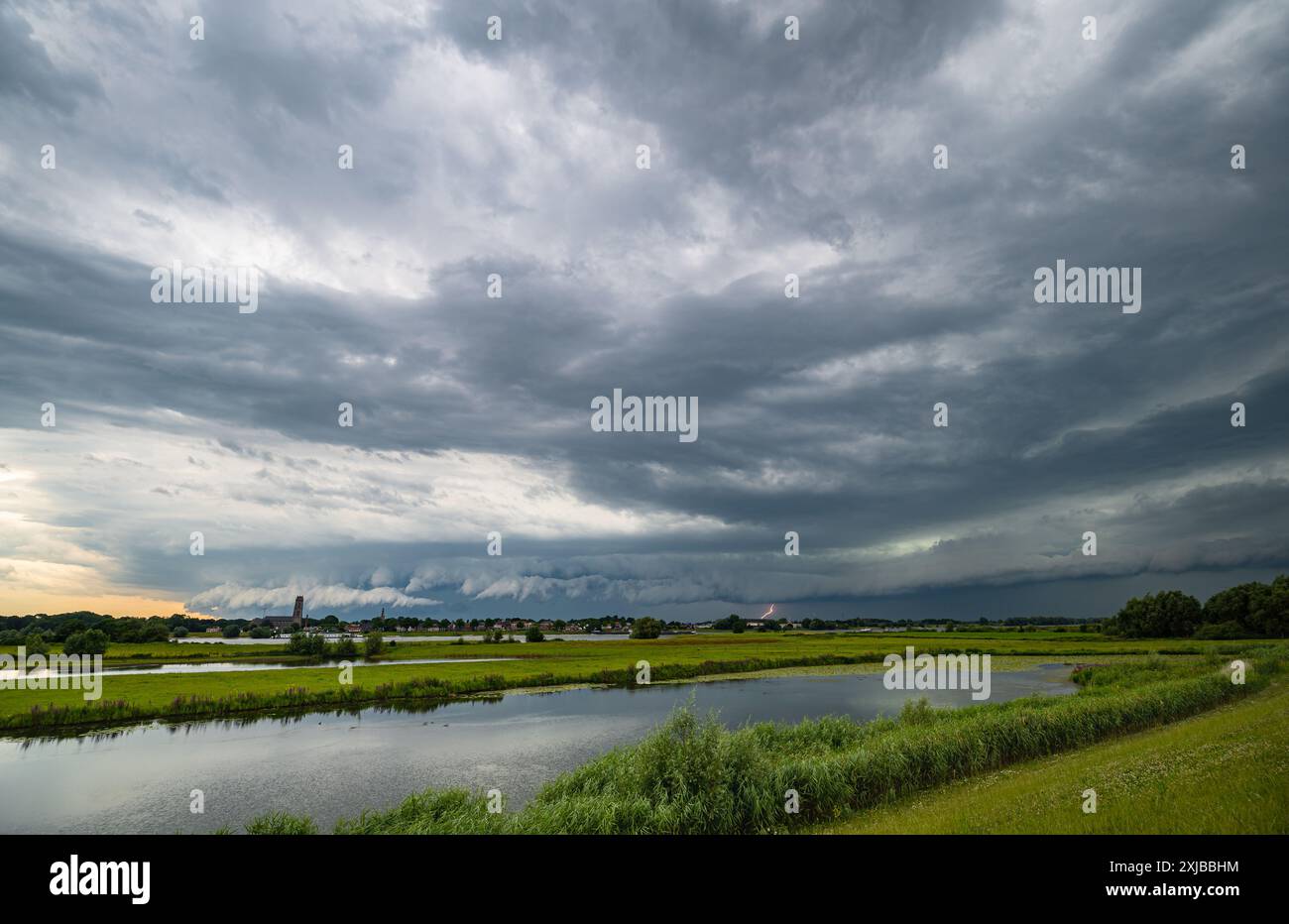 Cielo tempestoso con fulmini lontani sull'area del fiume olandese Foto Stock