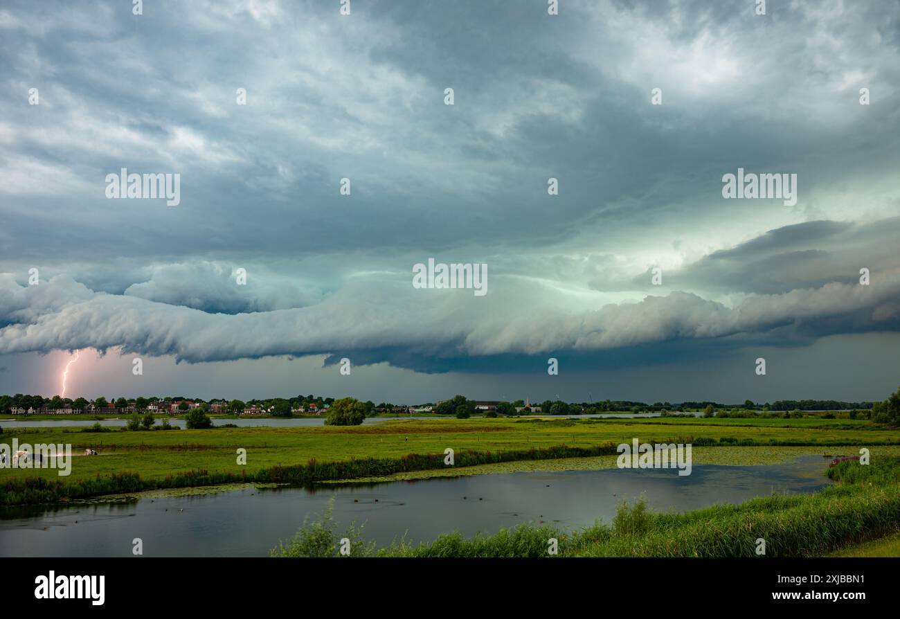 Vista spettacolare di una nuvola d'arco con fulmini di una forte tempesta sul paesaggio del fiume olandese Foto Stock