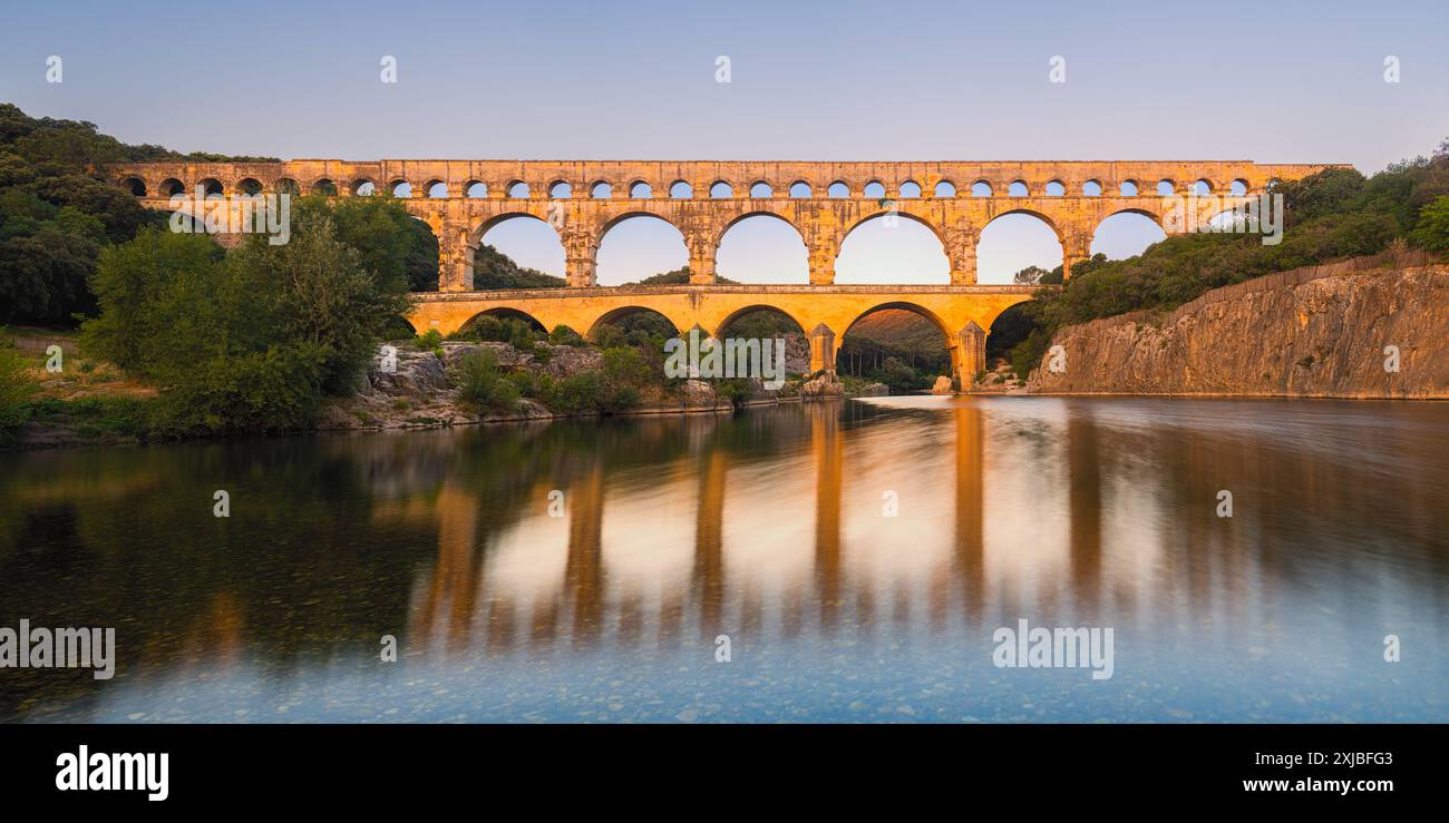 Un'alba panoramica estiva di 2:1, a Pont Du Gard, un acquedotto romano sul fiume Gardon, che fu poi ampliato in un ponte. La struttura è localizzata Foto Stock