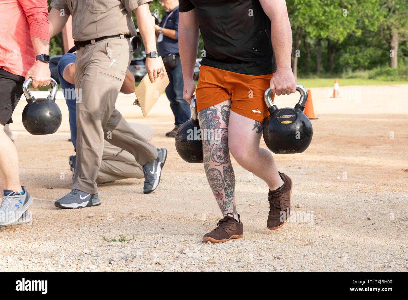 Florence Texas USA, 23 aprile 2024: Il Texas Department of Public Safety State Trooper lift kettlebell come parte della dodicesima competizione annuale Top Trooper. Gli ufficiali del DPS gareggiavano nella preparazione fisica, nel tiro, nella resistenza e nelle abilità di guida. Un totale di 120 soldati gareggiarono e ai due vincitori furono assegnati nuovi veicoli di pattuglia. ©Bob Daemmrich Foto Stock