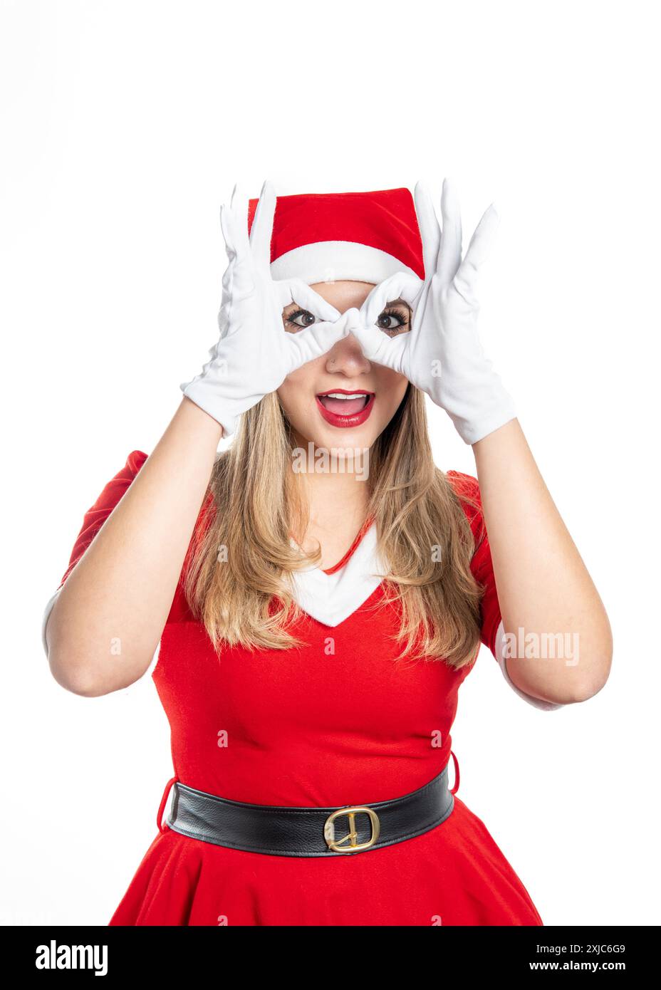 la giovane donna bionda vestita da mamma claus che guarda la macchina fotografica facendo un gesto con le mani come se avesse occhiali isolati su un dorso bianco Foto Stock