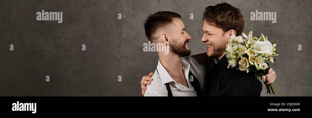 Due splendidi uomini in abiti eleganti si sorridono l'un l'altro in un abbraccio amorevole. Foto Stock