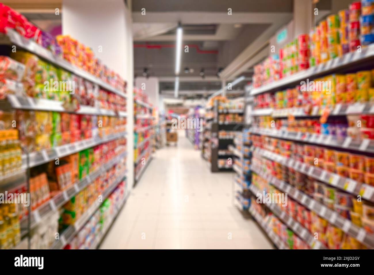 Corridoio del supermercato con scaffali colorati e negozi. Sfocatura astratta come sfondo. Foto Stock
