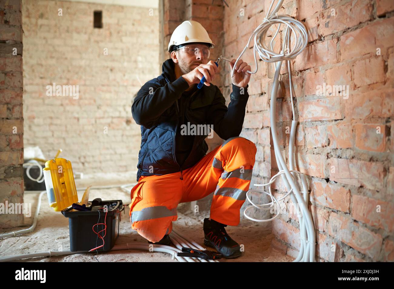 Elettricista in loco, installazione elettrica in corso. Foto Stock