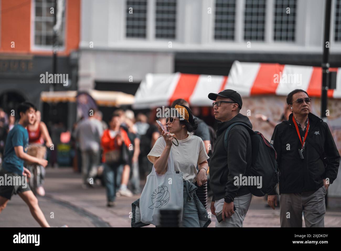 Cambridge, Regno Unito - 8 ottobre 2023 : tre persone camminano su una strada asfaltata a Cambridge, Regno Unito. Una persona tiene un telefono all'orecchio, un'altra ha uno zaino Foto Stock