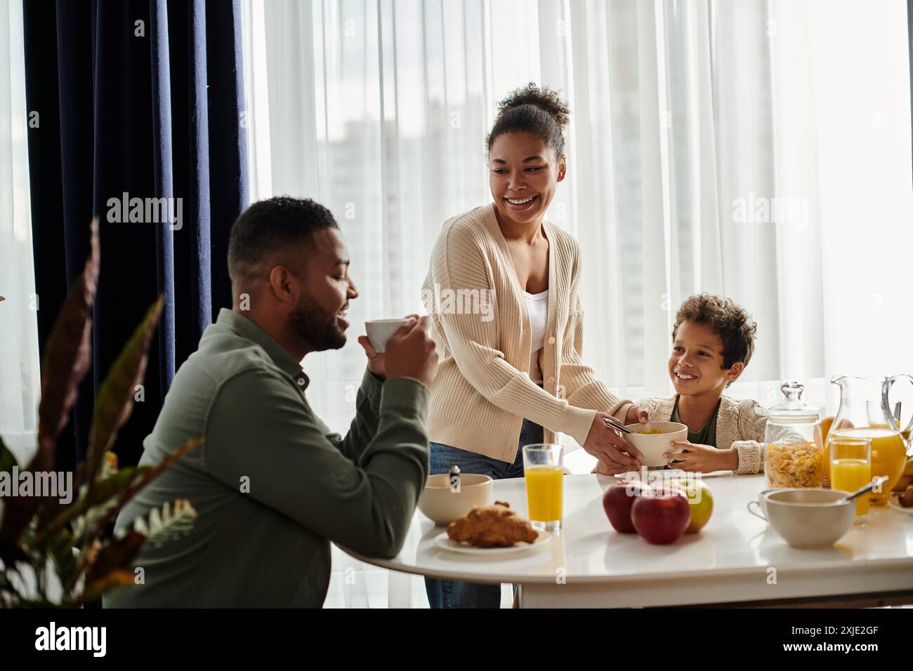 Una famiglia afro-americana affiatata si diverte a fare colazione insieme al tavolo. Foto Stock
