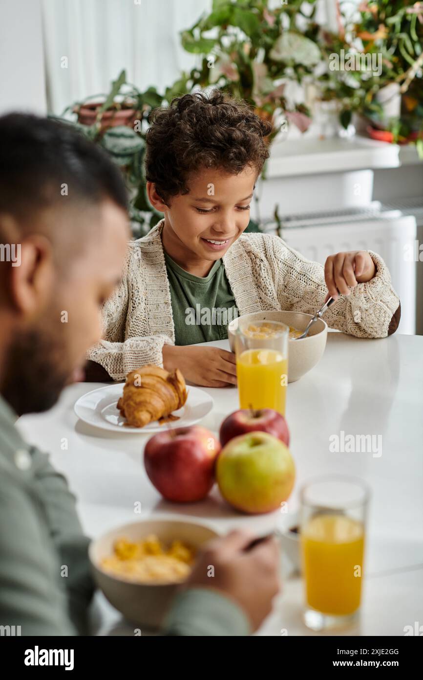 Una coppia felice si gode un pasto insieme a un tavolo con cibo. Foto Stock