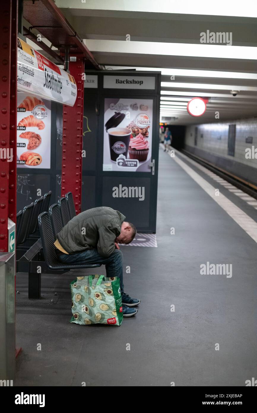 Senzatetto su un bech alla stazione della metropolitana U-Bahn di Berlino, capitale della Germania, Europa Foto Stock