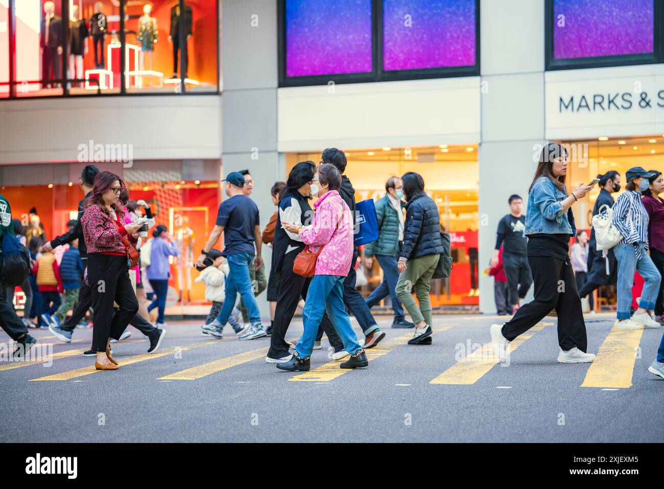 Hong Kong, Cina - 3 gennaio 2024: Persone che camminano attraverso un crocevia nel quartiere centrale di Hong Kong, Cina. Foto Stock