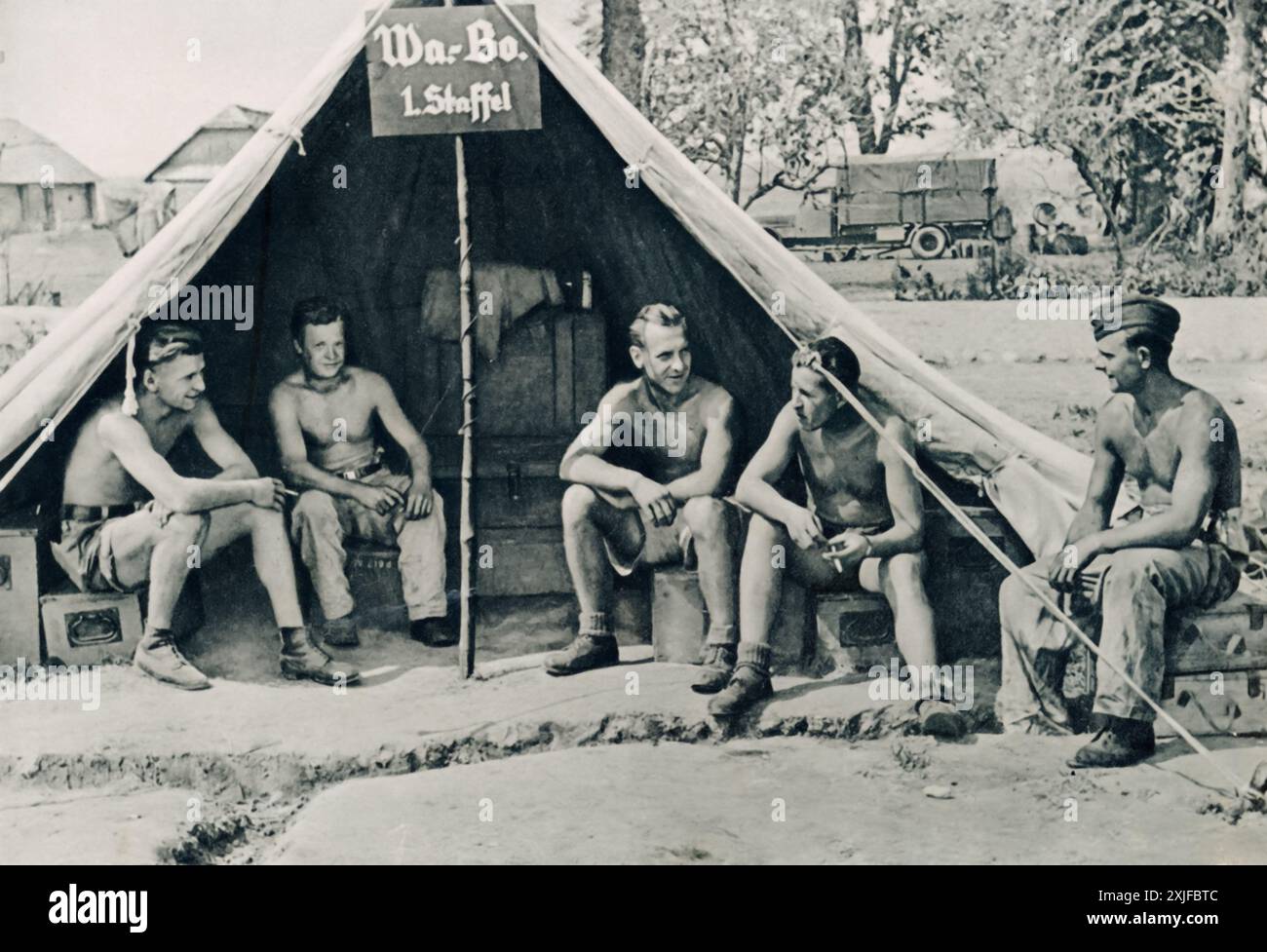 Una fotografia mostra un gruppo di soldati tedeschi responsabili del riarmo delle armi degli aerei, prendendo un momento di inattività mentre aspettano che gli aerei tornino da una missione. Scattata durante l'operazione Barbarossa nel 1941, questa immagine evidenzia il ruolo cruciale della Luftwaffe nell'avanzata tedesca contro le forze sovietiche sul fronte orientale durante la seconda guerra mondiale. Foto Stock