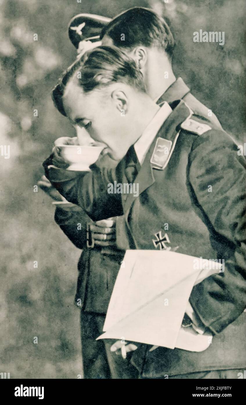 Una fotografia mostra il primo tenente G. che beve un caldo rinfresco da una tazza. Scattata durante l'operazione Barbarossa nel 1941, questa immagine cattura un breve momento di tregua per l'ufficiale della Luftwaffe durante un briefing sul fronte orientale. Foto Stock