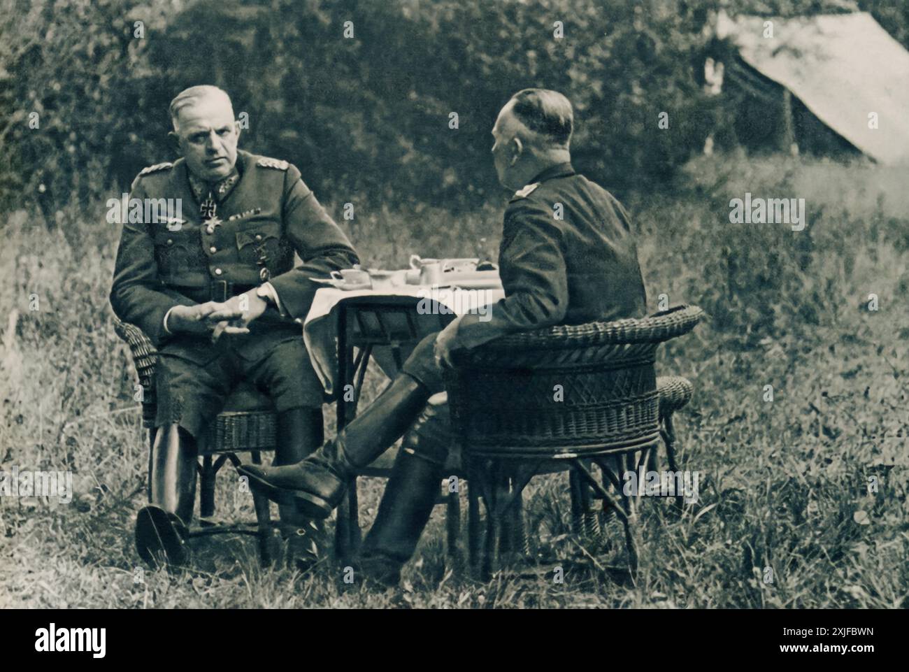 Una fotografia mostra il colonnello generale in conversazione con il generale dell'Aeronautica militare Wolfram von Richthofen, seduto fuori a un tavolo. Scattata durante l'operazione Barbarossa nel 1941, questa immagine cattura un momento di discussione strategica mentre le forze tedesche avanzavano contro le truppe sovietiche sul fronte orientale durante la seconda guerra mondiale. Foto Stock