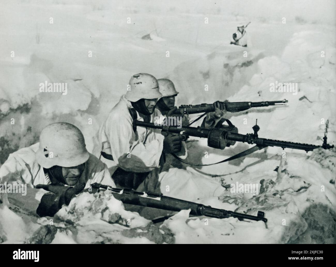 Una fotografia mostra i soldati tedeschi in una trincea innevata, che si preparano a difendersi dall'avanzata delle forze sovietiche. Scattata durante l'operazione Barbarossa nel 1941, questa immagine evidenzia le dure condizioni e gli intensi combattimenti a terra affrontati dalle truppe tedesche mentre avanzavano sul fronte orientale durante la seconda guerra mondiale. Foto Stock