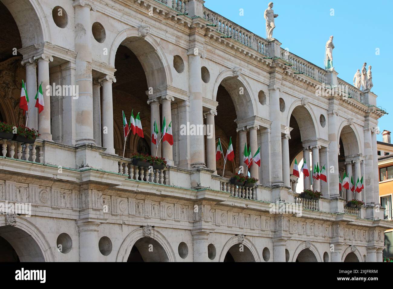 Vicenza, vi, Italia - 10 maggio 2024: Molte bandiere italiane sulla Basilica Palladiana, il monumento più famoso della città Foto Stock