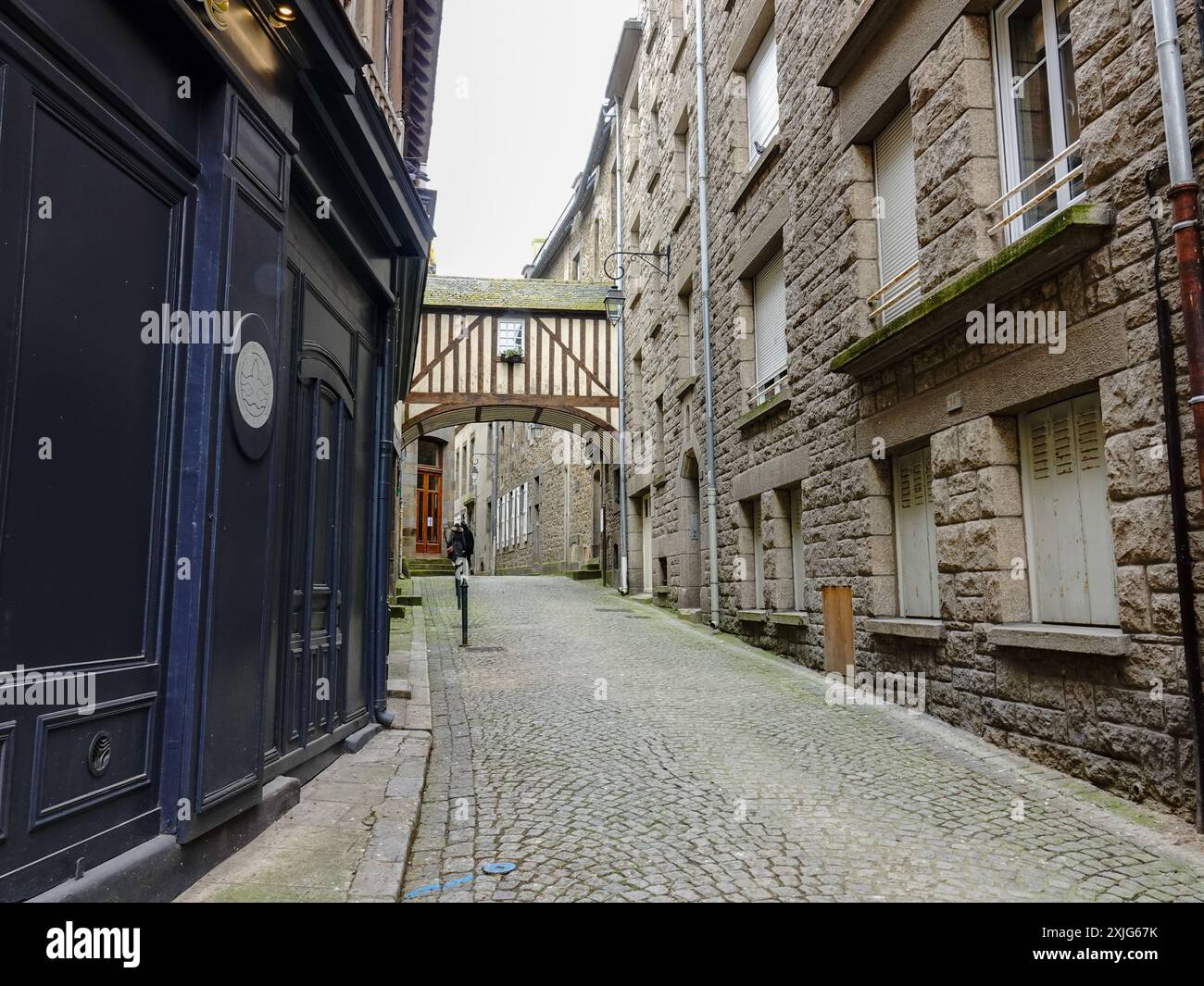 Sopra il passaggio che attraversa la strada, due persone esplorano all'interno delle mura, Intra muros, la città vecchia in rue des Vieux Remparts, Saint-Malo, Francia. Foto Stock