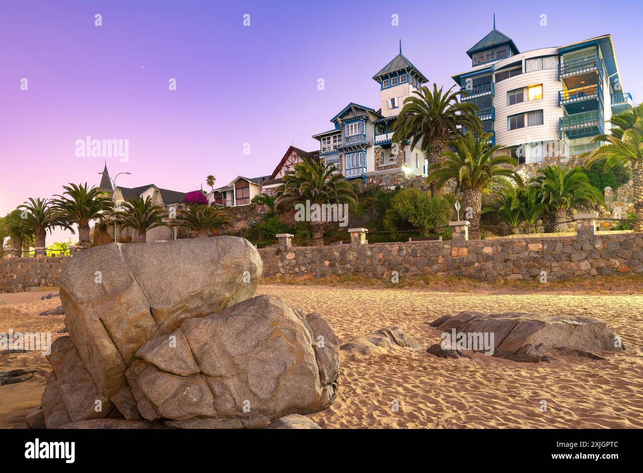 Il crepuscolo si adagia sulla pittoresca cittadina costiera di Papudo, gettando un sereno bagliore viola sulla costa rocciosa che mette in risalto la sua affascinante architettura costiera. Foto Stock
