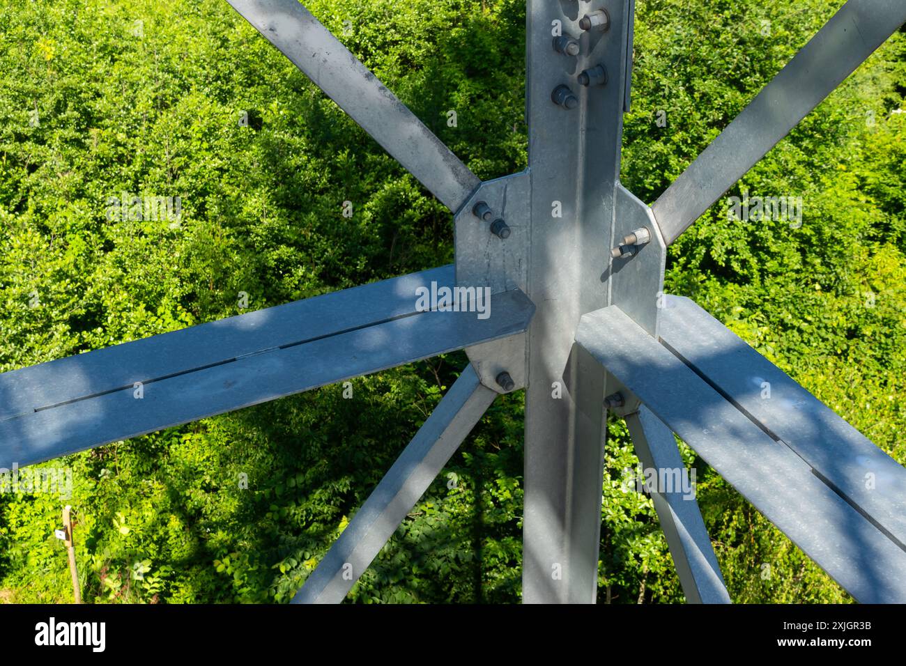 Collegamenti imbullonati di elementi in acciaio della torre di osservazione. Dettagli costruttivi in acciaio zincato su sfondo verde Foto Stock